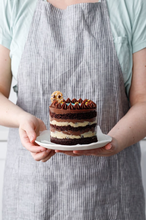 Person holding a plate with a mini naked layer cake to show the actual size/scale of the cake