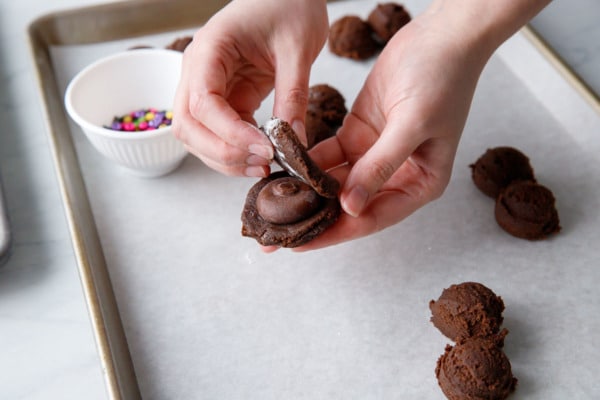 Stuffing the discs of frozen ganache in the middle of the cookie dough