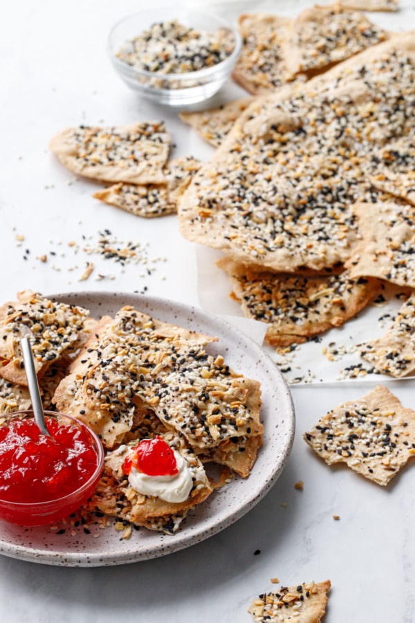 Plate with Homemade Everything Crackers, bowl of pepper jelly, one cracker topped with cream cheese and pepper jelly