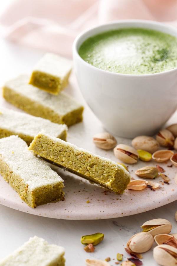 Rectangles of Matcha Pistachio Shortbread with a mug of matcha