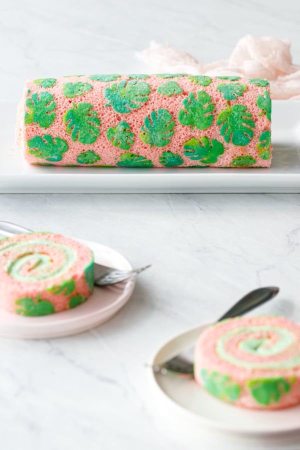 Roll Cake with tropical Leaf design, two plates with slices and forks in the foreground