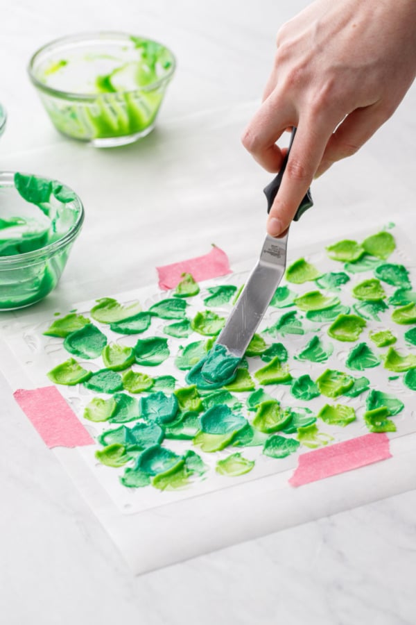 Dabbing three colors of cake batter onto the stencil