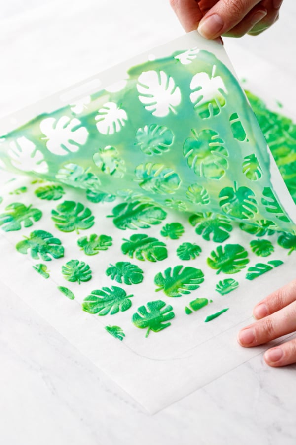 Peeling off the stencil to reveal the monstera leaf design