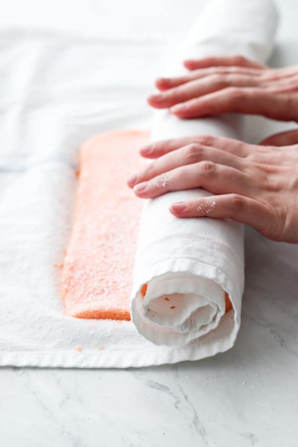 Rolling the warm cake up in a tea towel to prevent cracking