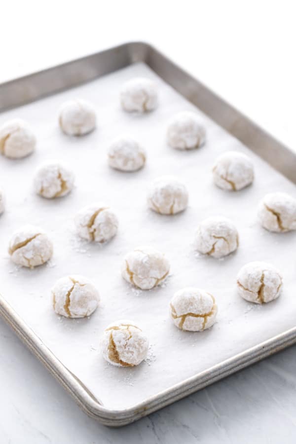 Sheet pan lined with parchment, rows of baked Amarena Cherry Amaretti cookies