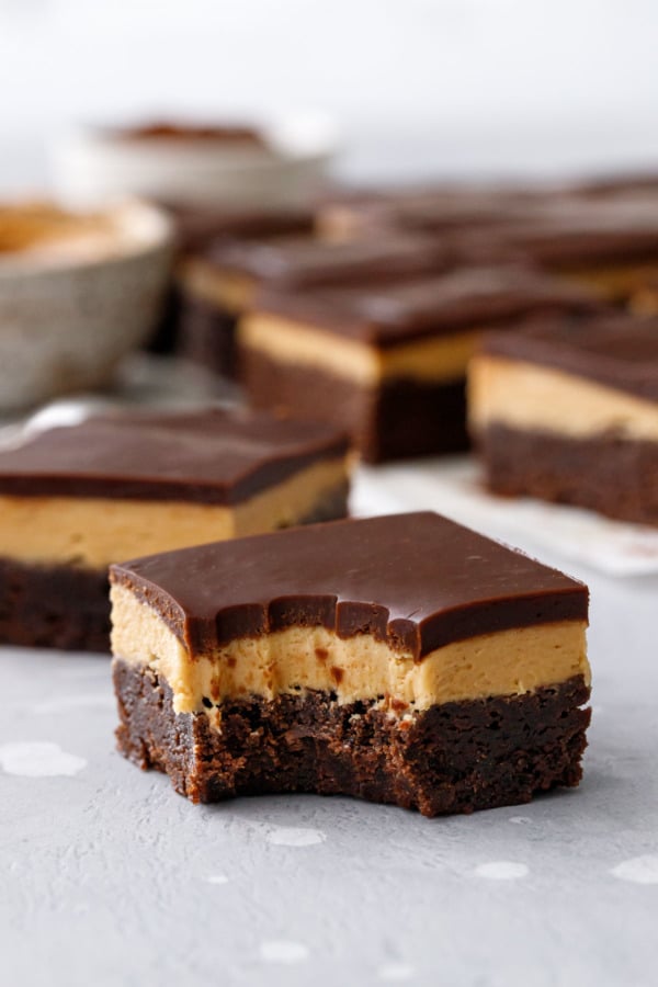 Bite of Milk Chocolate Peanut Butter Ganache Brownies, showing the three distinct layers