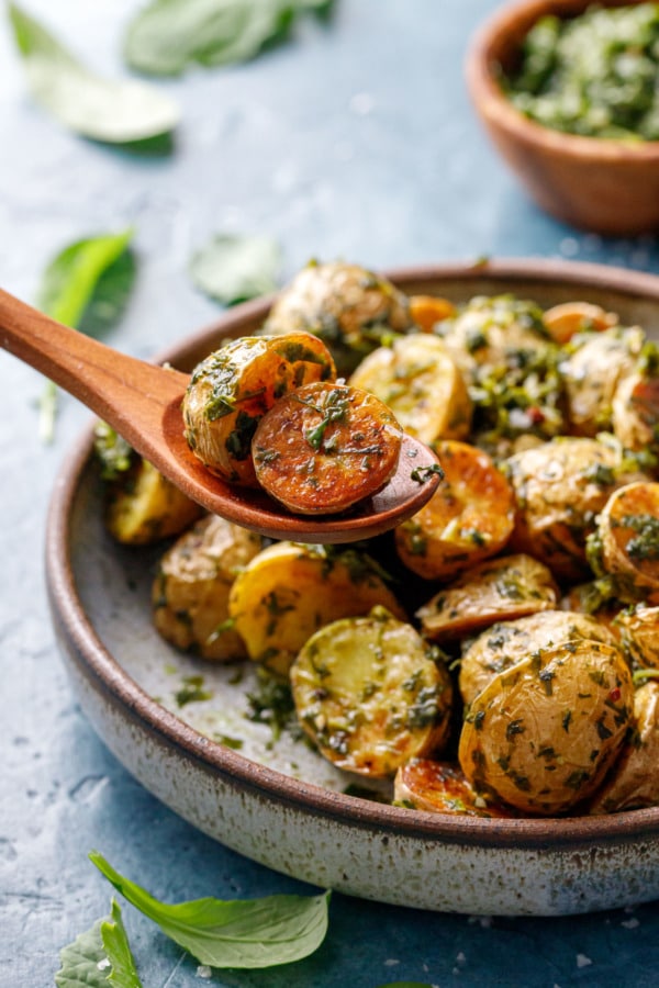 Wooden spoon lifting a few potatoes out of the bowl