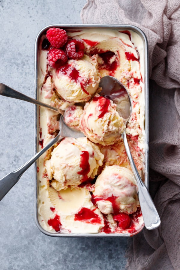 Overhead, silver loaf pan with Toast & Jam Ice Cream, messy scoops and multiple spoons.