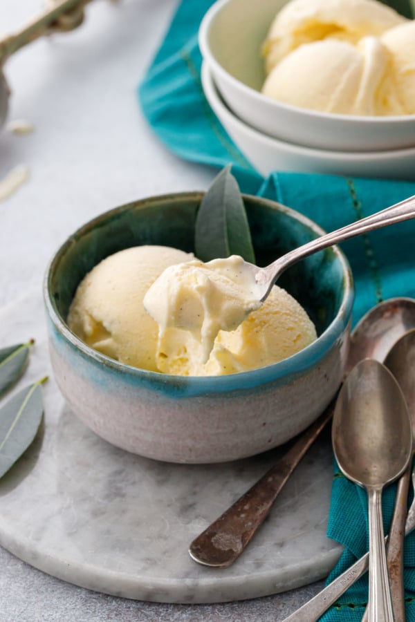 Spoon lifting to show the creamiest texture of this homemade bay leaf and vanilla ice cream