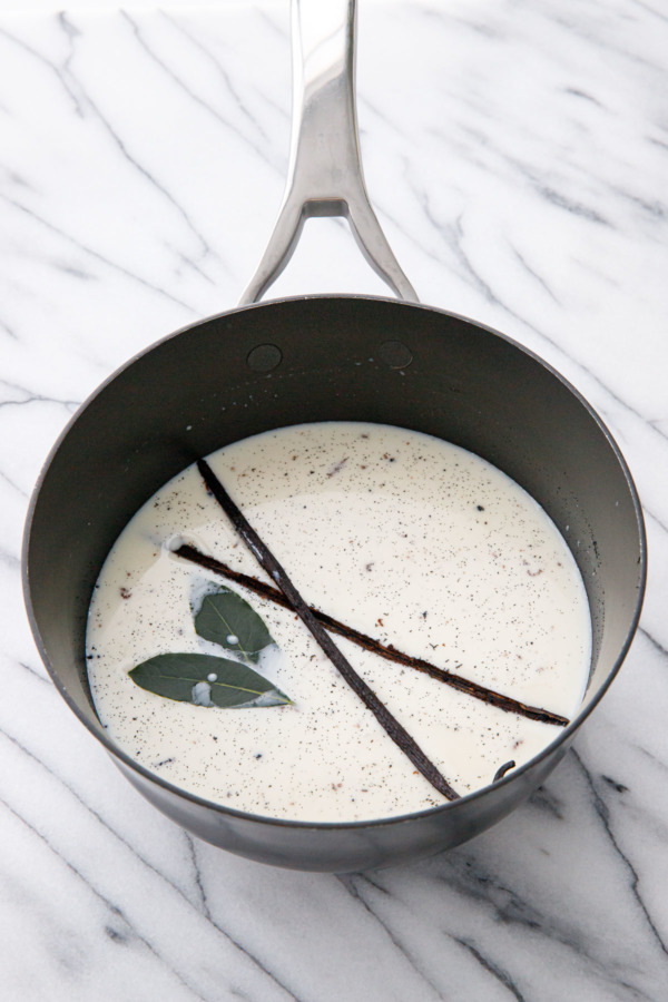 Steeping fresh bay leaves and vanilla beans in a pot of cream.