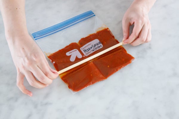 Ziptop bag with homemade tomato sauce, use a chopstick to divide the sauce into serving size segments