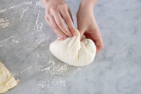 Stretch and tuck corners of dough into a ball shape.