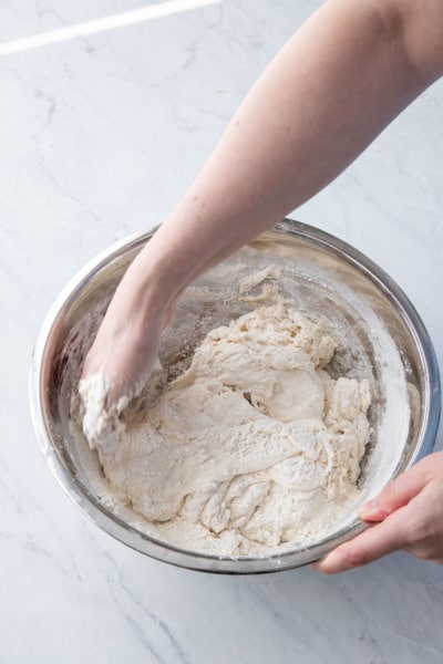 Use a pinching motion alternating with a fold to fully mix the poolish into the flour.