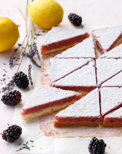 Blackberry Lavender Lemon Bars cut into triangles and dusted with sugar