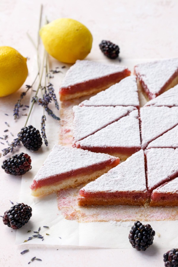 Blackberry Lavender Lemon Bars cut into triangles and dusted with sugar