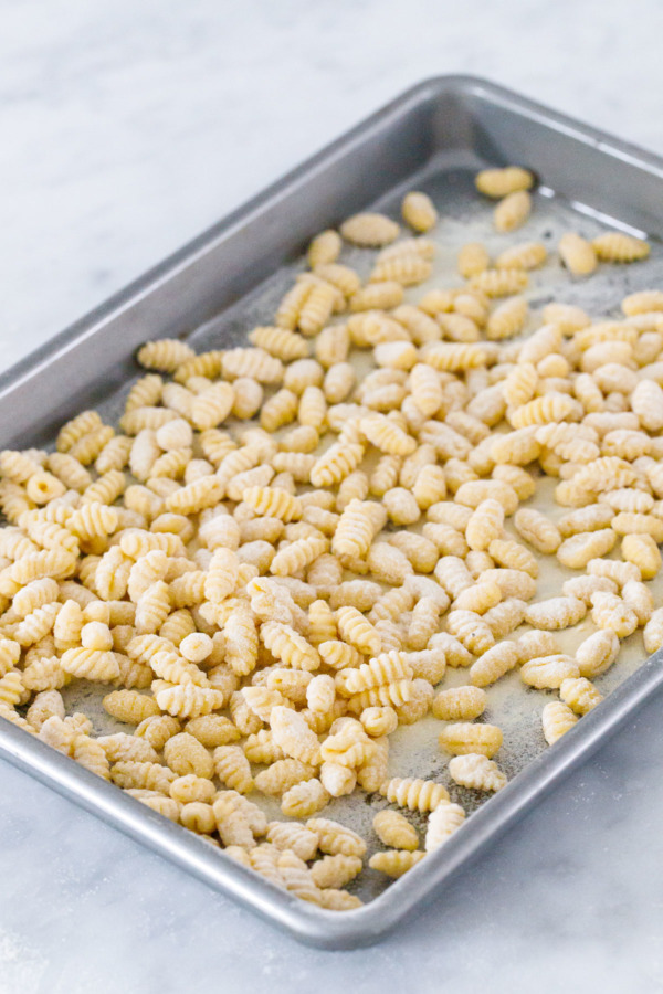 Cookie sheet filled with homemade gnochetti sardi pasta, ready to freeze