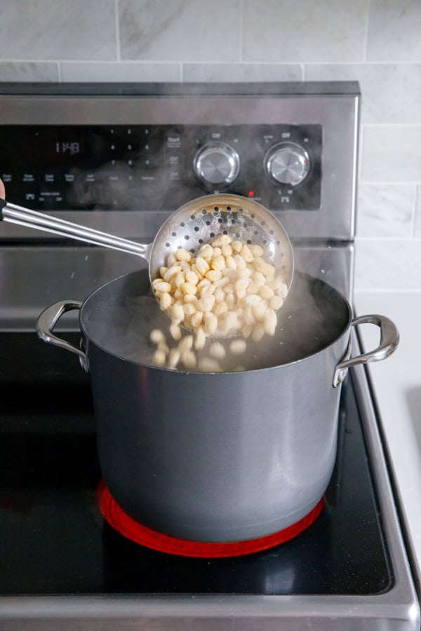 Cooking homemade pasta on a stovetop in a pot of boiling water