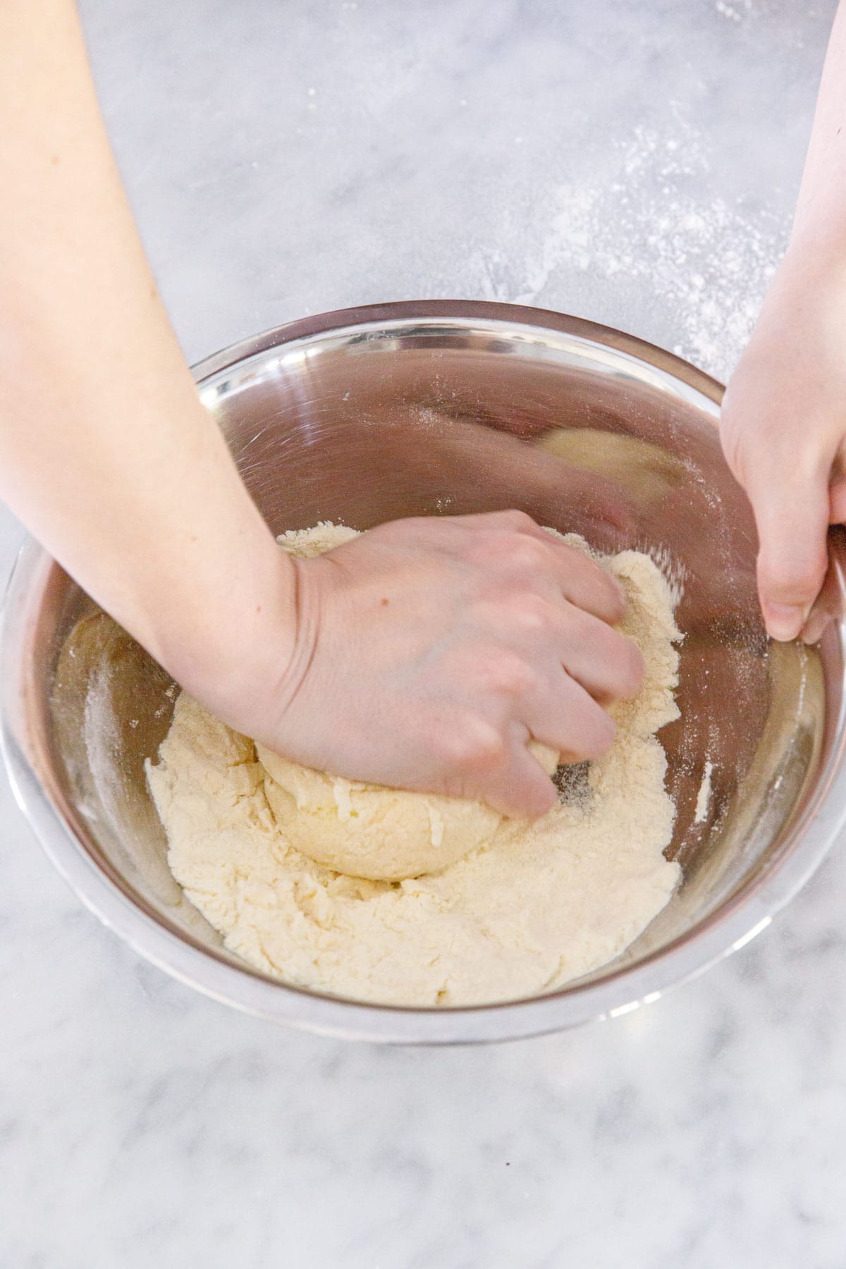 Kneading homemade pasta dough until it comes together.