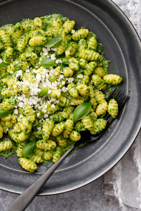 Closeup, overhead bowl of gnochetti sardi with pesto sauce and fork