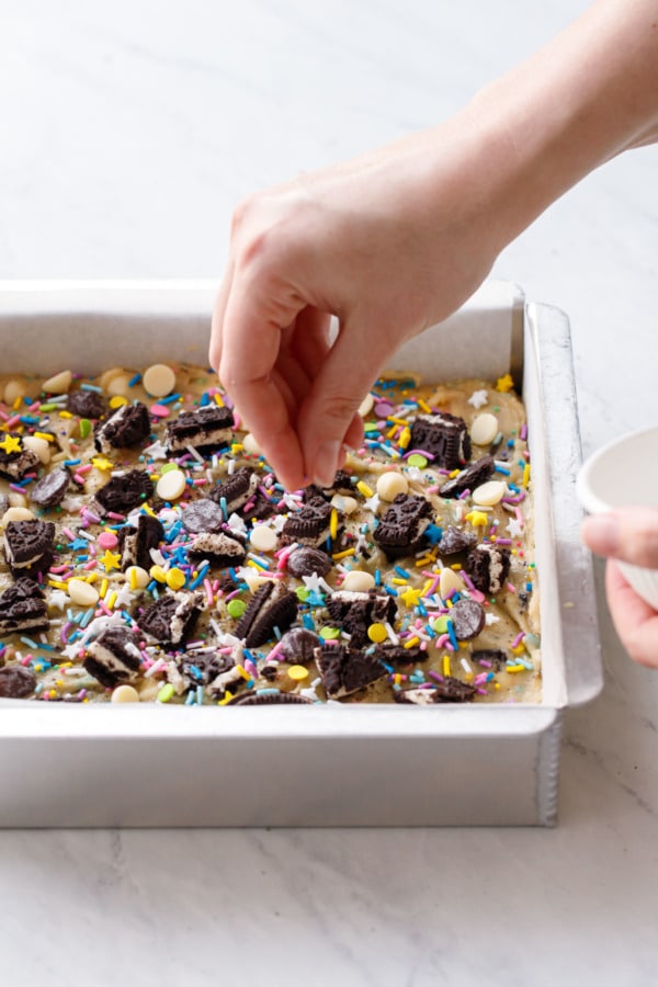 Sprinkling more colorful sprinkles on top of the blondies before baking