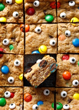 Square grid of cut Monster Cookie Bars, one tilted on its side to show cross-section