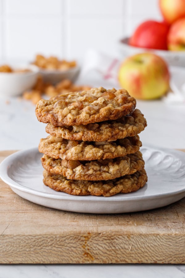 Stack of 5 Toffee Apple Oatmeal Cookies on a ceramic plate on a thick rustic wood board
