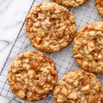 Overhead, wire rack with Toffee Apple Oatmeal Cookies on an angle, on a marble background