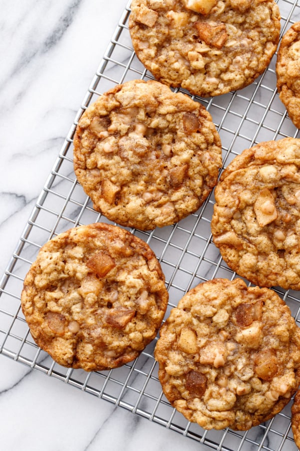 Overhead, wire rack with Toffee Apple Oatmeal Cookies on an angle, on a marble background