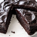 One triangular slice cut from a Sour Cream Chocolate Cake, with swirls of glossy chocolate frosting