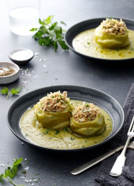 Dark gray bowls with Hungarian Stuffed Kohlrabi (one bigger and one smaller bulb) surrounded by a green kohlrabi green puree