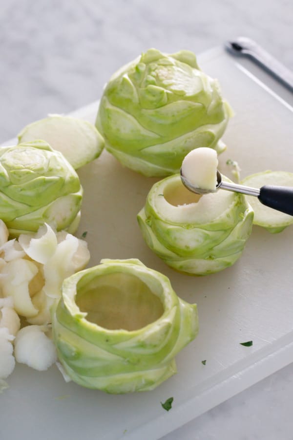 Showing the process of hollowing out the kohlrabi bulbs with a melon baller
