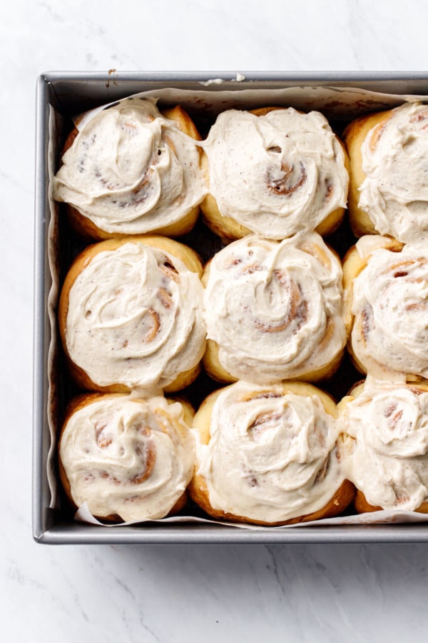 Overhead, pan of Brown Butter Cinnamon Rolls with creamy frosting