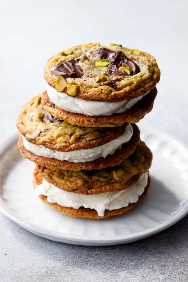 Stack of three Salted Pistachio & Dark Chocolate Chunk Cookies sandwiched with vanilla bean ice cream