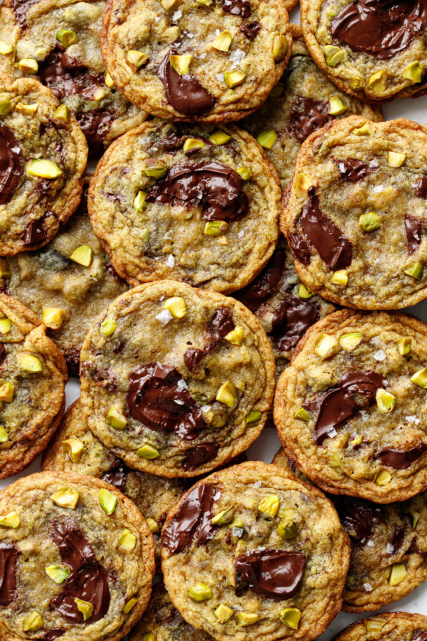 Overhead, pile of Salted Pistachio & Dark Chocolate Chunk Cookies, showcasing the dark chocolate puddles and chopped green pistachios on top.