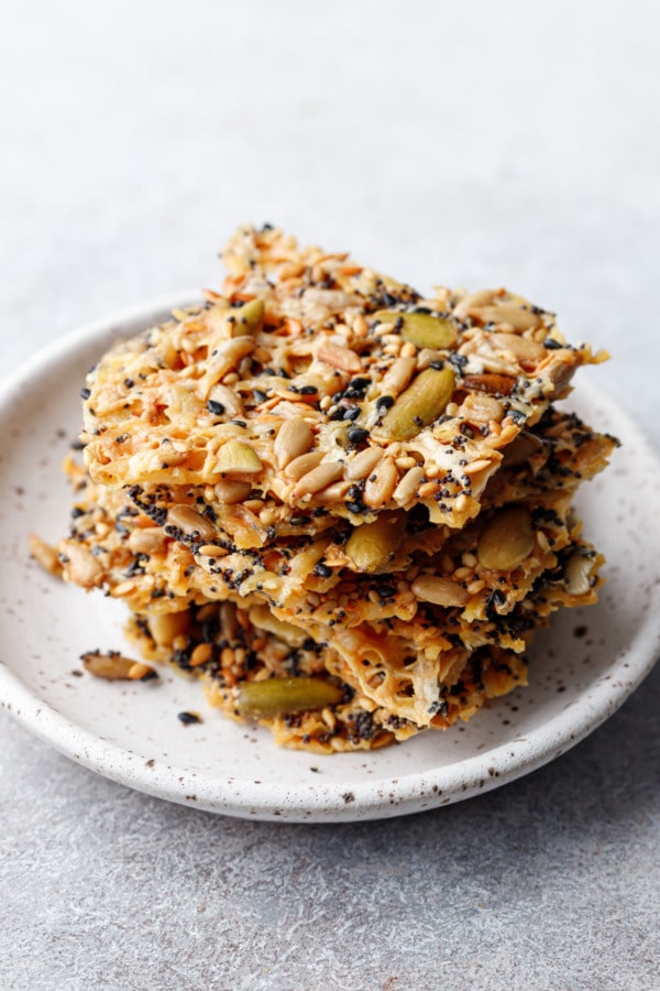Stack of Seeds and Cheese Cracker pieces on a speckled ceramic plate