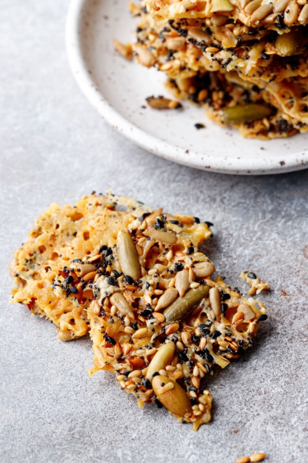 Two rough broken pieces of Seeds and Cheese Crackers showing the texture of the top and bottom