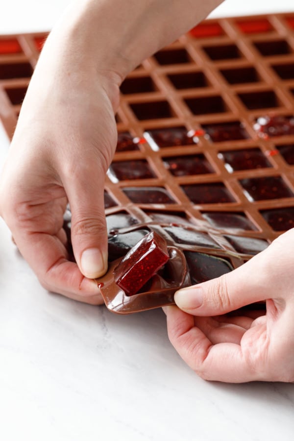 Popping the set gummy candy out of the square silicone molds.