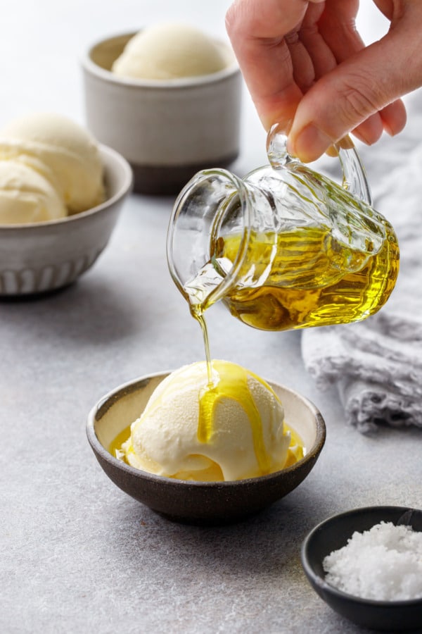 Pouring extra virgin olive oil over a scoop of olive oil ice cream