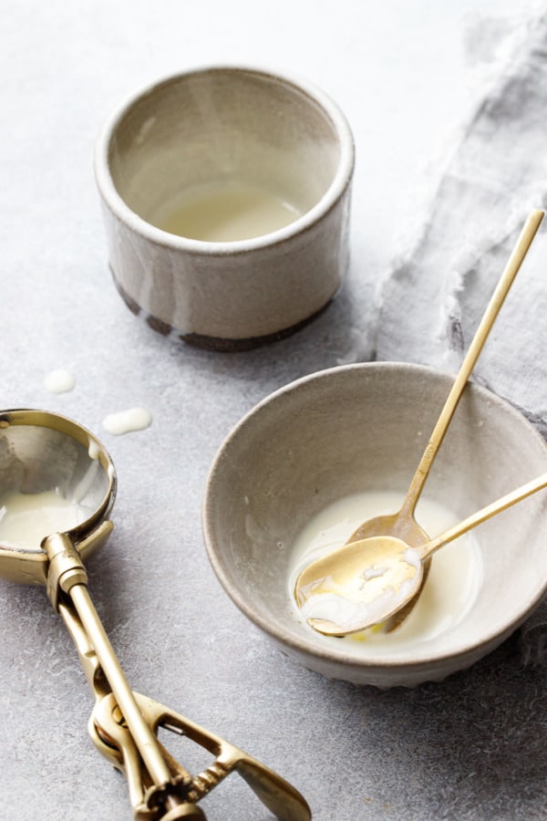 The aftermath of the ice cream shoot, melted bits of liquid ice cream in ceramic bowls and drips all over.