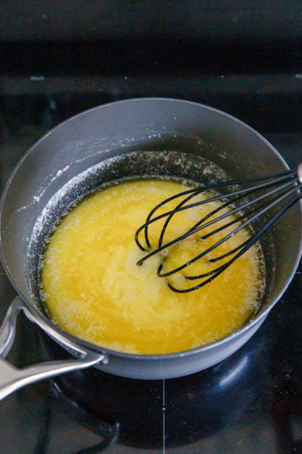 Saucepan with melted butter, white chocolate, and sugar appears slightly separated.
