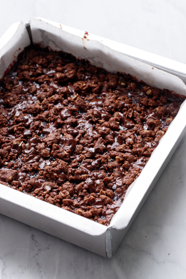 Fresh out of the oven Chocolate Raspberry Crumb Bars in a silver baking pan, marble background.