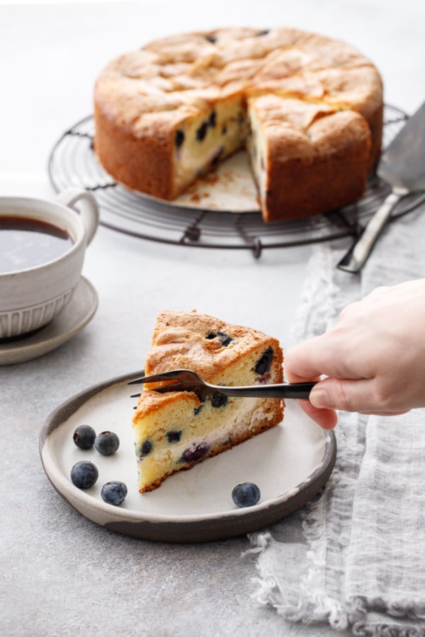 Slice of Blueberry Cream Cheese Coffee Cake with a fork cutting out a bite.