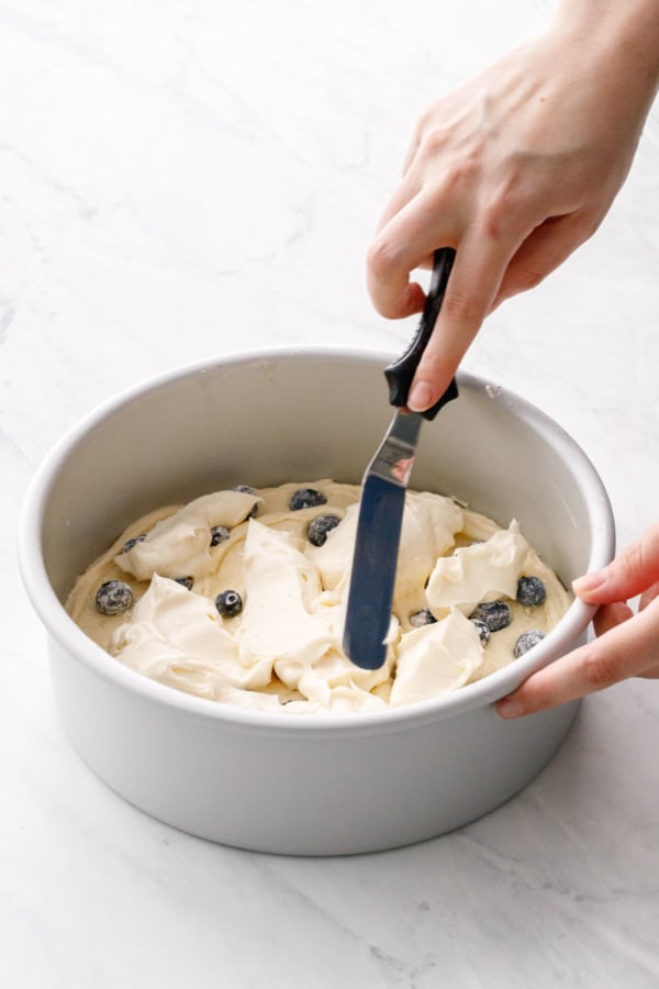 Spreading the cream cheese filling onto the first layer of batter.