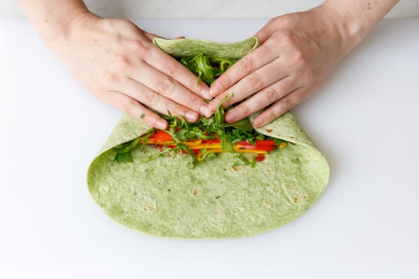 How to fold a sandwich wrap, step 1: fold in the bottom and start to roll.