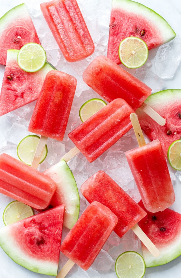 Ice cold watermelon wedges on wide popsicle sticks.