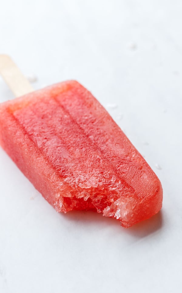 Closeup bite out of Tequila Watermelon Popsicle, showing the crystalline structure of the frozen popsicle.
