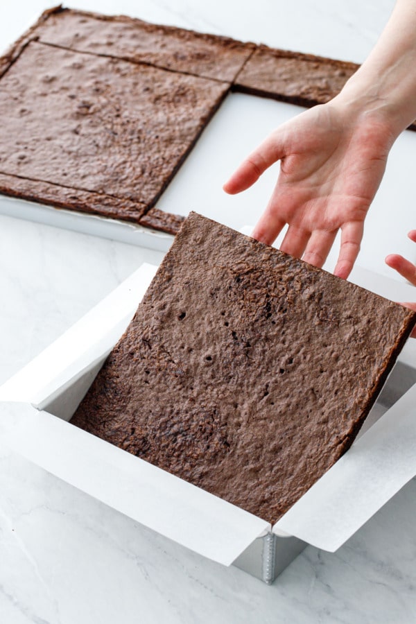 How to make brownie ice cream sandwiches: ease one square of brownie into the bottom of a parchment-lined 8-inch square pan.