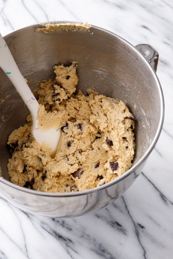 Amaretto Chocolate Chip Cookie dough in a metal mixing bowl, ready to bake.