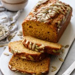 Spiced Pumpkin Banana Bread with three slices laying down, cup of coffee in the background.