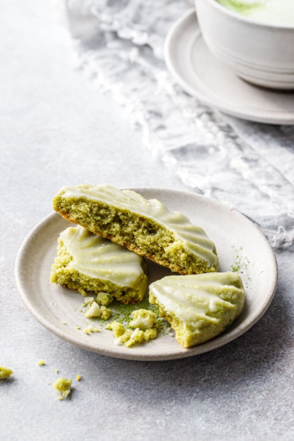 Small plate with a Glazed Matcha Sugar Cookie crumbled into pieces to show the interior texture.